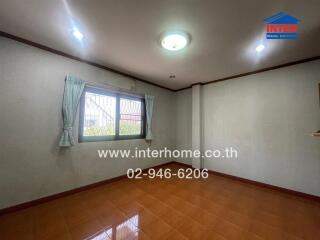 Spacious and well-lit empty living room with large window and tiled floor