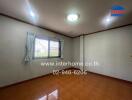 Spacious and well-lit empty living room with large window and tiled floor