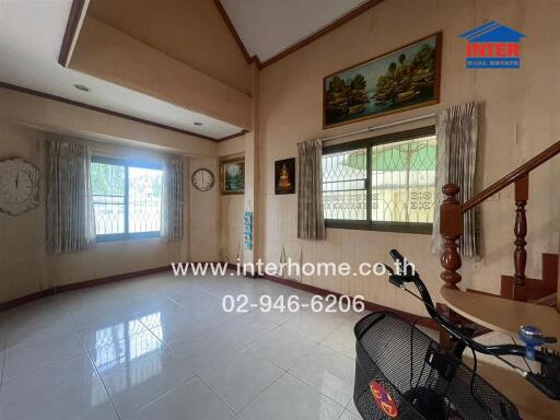 Spacious and well-lit living room with large windows and elegant decor