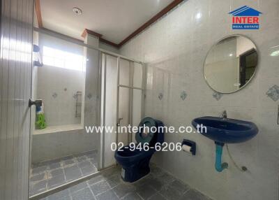 Spacious modern bathroom with shower stall and blue fixtures