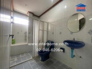 Spacious modern bathroom with shower stall and blue fixtures