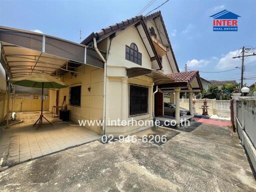 Exterior view of a two-story residential house with a carport