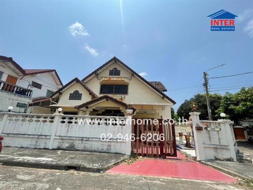 Spacious two-storey residential house with a gated entrance under clear blue skies