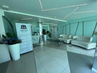 Spacious modern lobby with white sofas and green plants