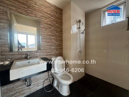 Modern bathroom with textured walls, floating sink, and wall-mounted toilet