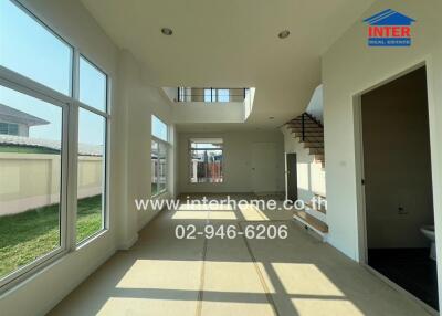 Spacious unfurnished living room with large windows and high ceiling
