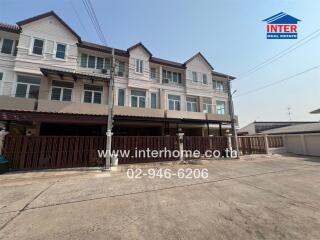 Exterior view of a row of modern townhouses with wooden accents and covered parking