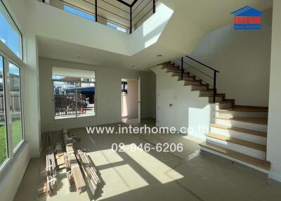 Bright and spacious living room with modern staircase and large windows