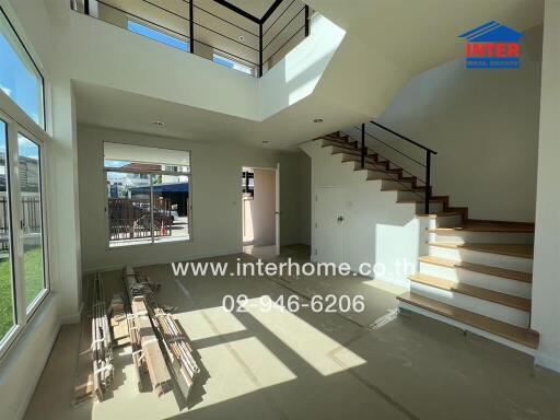 Bright and spacious living room with modern staircase and large windows