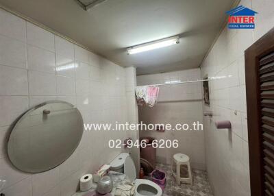Compact bathroom with white tiling and essential fixtures