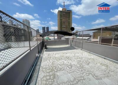 Urban rooftop area with protective fencing and a view of city skyscrapers