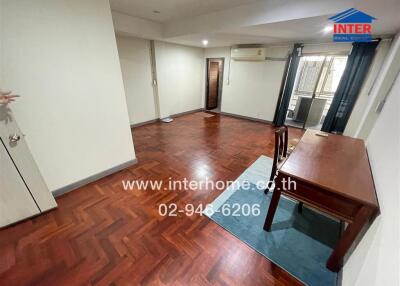 Spacious living room with wooden flooring and natural light