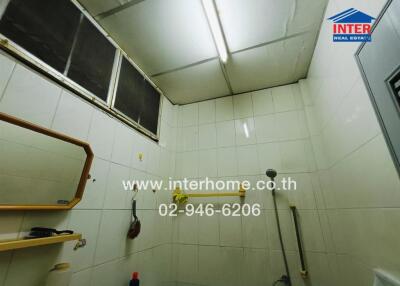 Bright and compact bathroom interior with white tiles and essential fixtures