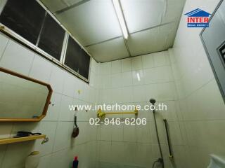 Bright and compact bathroom interior with white tiles and essential fixtures