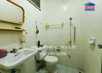 Small white-tiled bathroom with basic fixtures