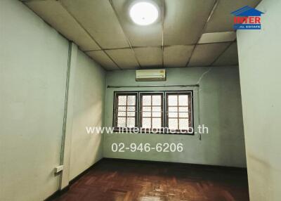 Spacious empty bedroom with large windows and air conditioning unit