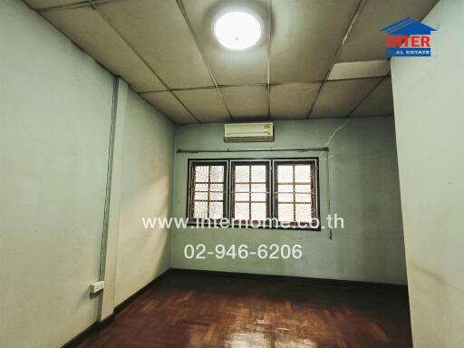 Spacious empty bedroom with large windows and air conditioning unit