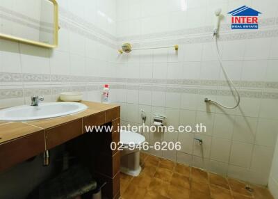 Clean and functional bathroom with wooden vanity and tiled walls