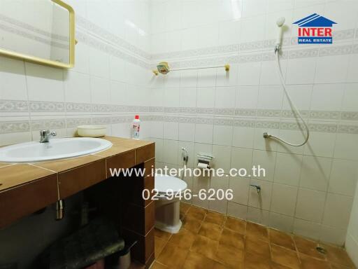 Clean and functional bathroom with wooden vanity and tiled walls