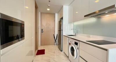 Modern compact kitchen with built-in appliances and marble flooring