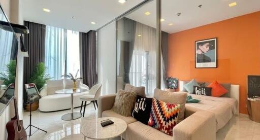 Modern living room with vibrant orange accent wall and contemporary furnishings