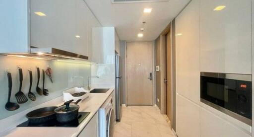 Modern kitchen with stainless steel appliances and ample lighting in a sleek apartment