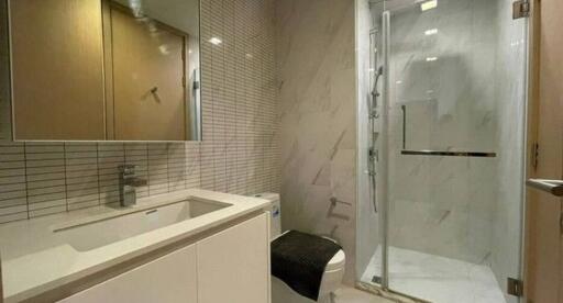 Modern bathroom with glass shower and marble walls