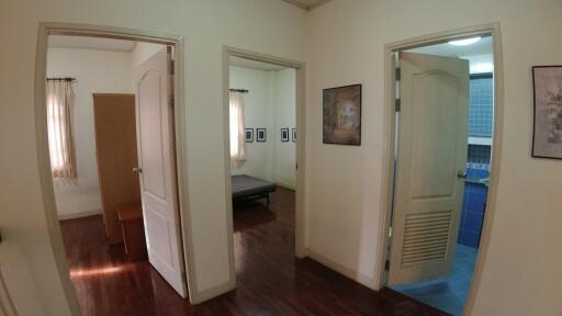 Spacious hallway with multiple doorways leading to different rooms including a bedroom and bathroom