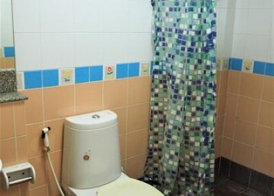 Compact bathroom with colorful tile accents and basic amenities