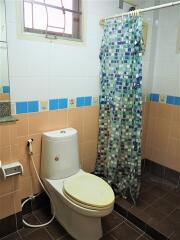 Compact bathroom with colorful tile accents and basic amenities