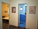 View of a hallway linking bedroom and bathroom, adorned with framed artwork