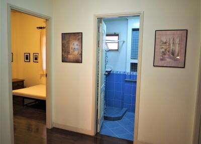 View of a hallway linking bedroom and bathroom, adorned with framed artwork