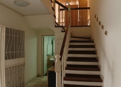 Spacious staircase area with wooden stairs and tiled flooring