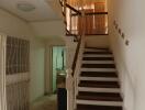 Spacious staircase area with wooden stairs and tiled flooring