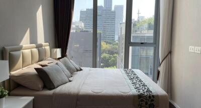 Modern bedroom with city view through large windows