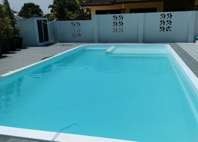 Spacious outdoor pool with elegant tile flooring and privacy walls