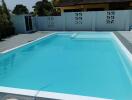 Spacious outdoor pool with elegant tile flooring and privacy walls