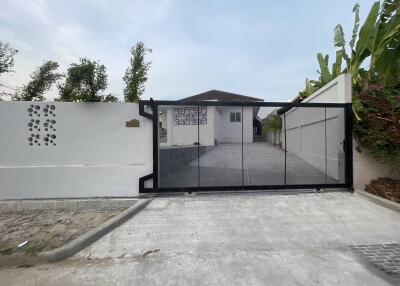 Modern house entrance with secure gate and well-maintained driveway