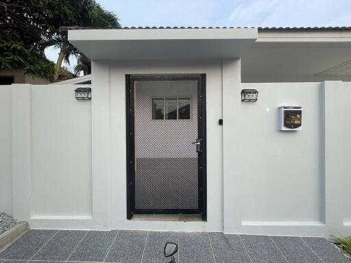 Modern home entrance with secure gate and stylish wall lamps