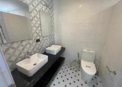 Modern bathroom with dual sinks and decorative tiling