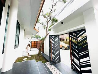 Modern house entrance with open gate and a person