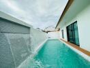 Luxurious residential pool with water feature and adjacent building