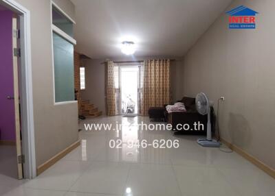 Spacious living room with glossy tiled flooring and ample natural light