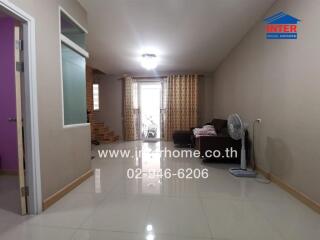 Spacious living room with glossy tiled flooring and ample natural light