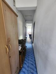 Narrow residential hallway with blue flooring and white walls