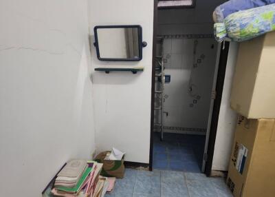 Cluttered entryway leading to a bathroom, with storage and items on the floor