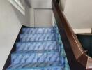 Interior view of a staircase with blue patterned tiles
