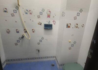 Compact bathroom with blue tile flooring and decorated wall tiles