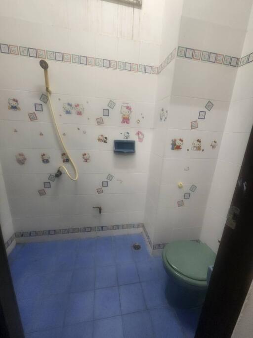Compact bathroom with blue tile flooring and decorated wall tiles