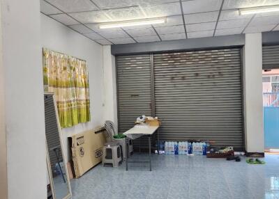 Spacious indoor area with tiled floor and security shutters